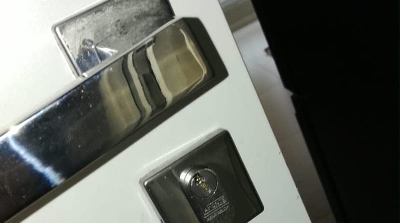 Fechadura e maçaneta de porta residencial branca, vistas de fora, em atendimento da Resgatou